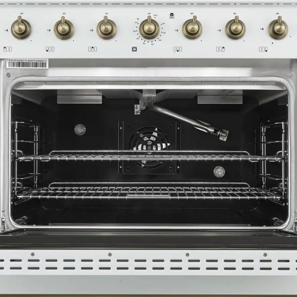Interior view of the Forno Antico 36-Inch Dual Fuel Range in white, showcasing a spacious blue enamel oven cavity, convection fan, and heavy-duty racks for multi-level cooking.