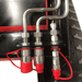 Detailed view of Katool KT-SK26W skid steer loader hydraulic connectors with red protective caps.