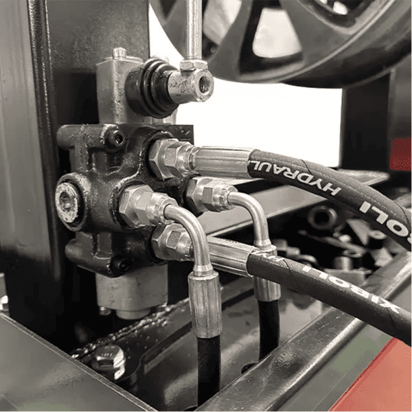 Close-up of hydraulic hoses and fittings on Katool KT-WL69 rim wheel straightening machine.