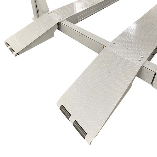 Extended steel ramps on Triumph NTR-32 four post auto lift for commercial trucks and buses.