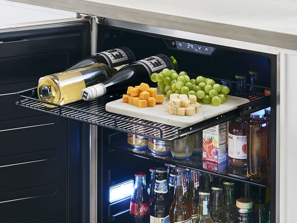 ZEPHYR Outdoor Beverage Cooler in outdoor setting with door open, showcasing full-extension wire rack for drinks or grill prep.
